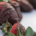 Chocolate-covered strawberries on a white plate, used to illustrate a recall of chocolate-covered frozen berries
