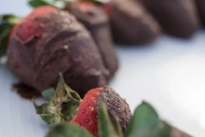 Chocolate-covered strawberries on a white plate, used to illustrate a recall of chocolate-covered frozen berries