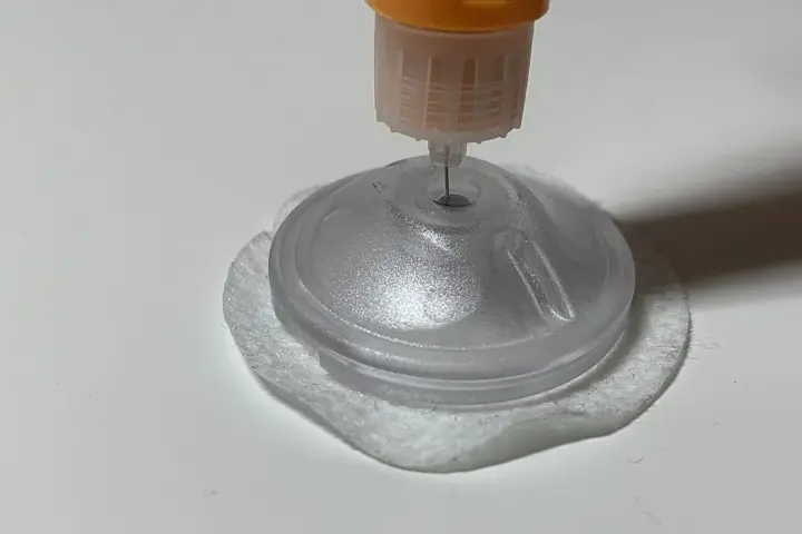 A continuous glucose monitor sensor being inserted with a medical applicator on a neutral surface