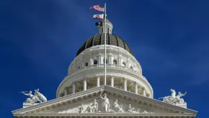 The dome and pediment of the California State Capitol building in Sacramento against a blue sky