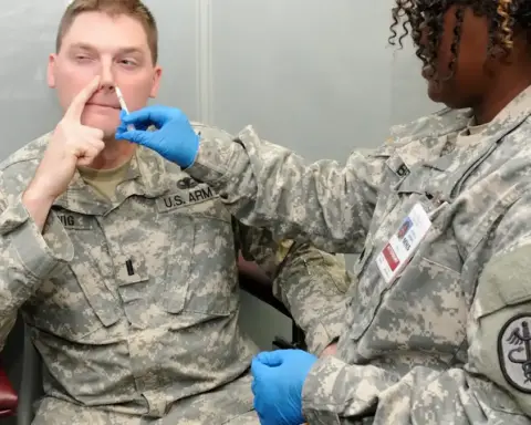 Nurse administering an influenza vaccination dose to an adult in a clinical health facility.