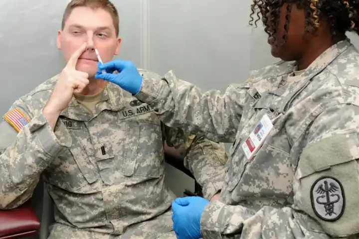 Nurse administering an influenza vaccination dose to an adult in a clinical health facility.