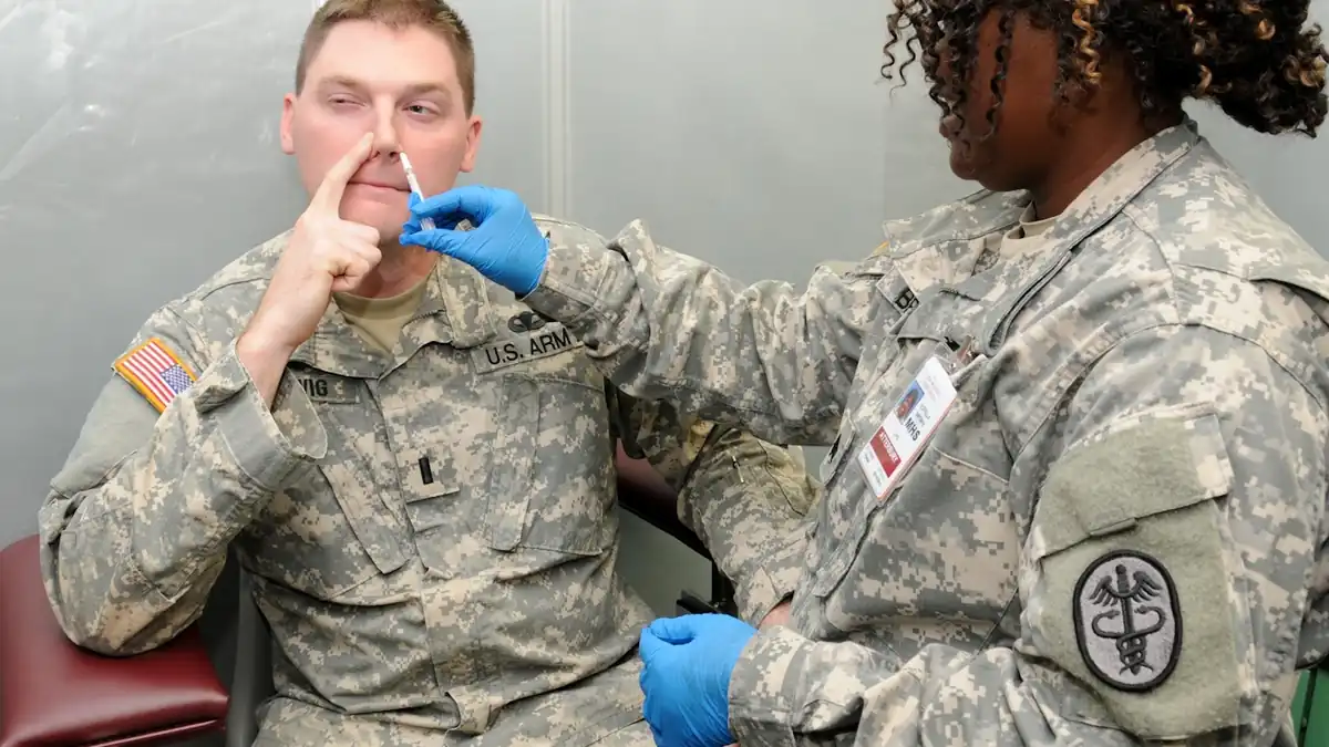 Nurse administering an influenza vaccination dose to an adult in a clinical health facility.