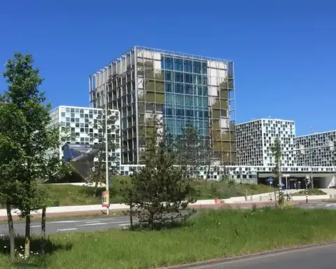 Exterior facade of the International Criminal Court building in The Hague showing modern glass panels and geometric architectural towers.