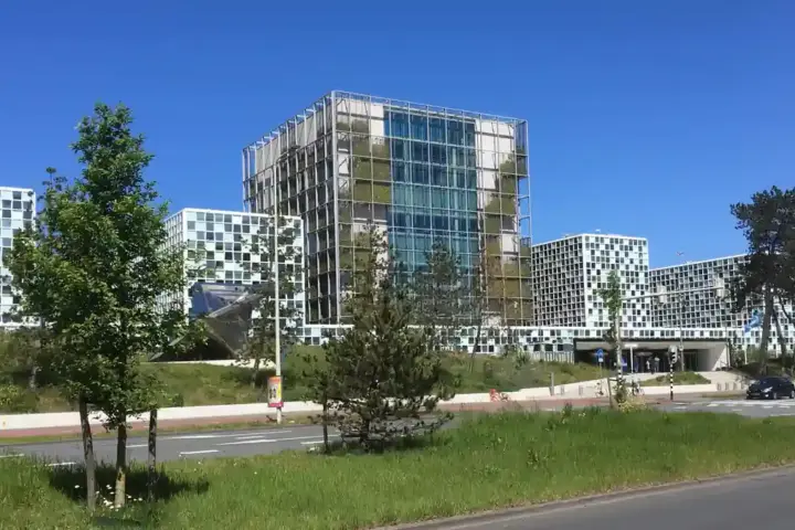 Exterior facade of the International Criminal Court building in The Hague showing modern glass panels and geometric architectural towers.
