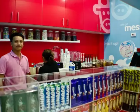 Commercial beverage prep counter showing electric blender jars and stainless-steel drink mixing stations in a cafe kitchen.