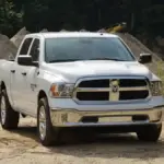 Modern Ram 1500 pickup truck parked on pavement showing front fascia, cab profile, and wheels.