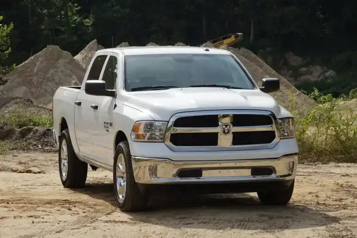Modern Ram 1500 pickup truck parked on pavement showing front fascia, cab profile, and wheels.