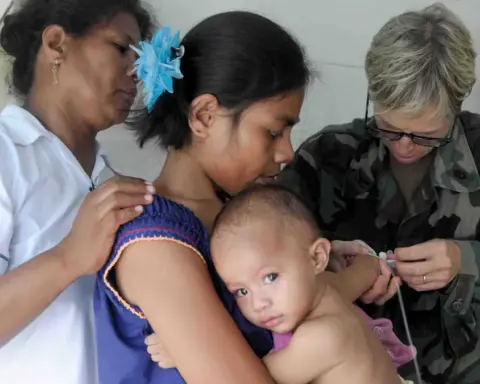 Healthcare physician using a medical stethoscope to listen to an infant chest and lungs during an examination.