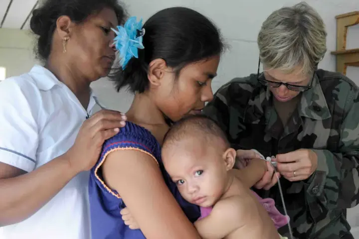 Healthcare physician using a medical stethoscope to listen to an infant chest and lungs during an examination.