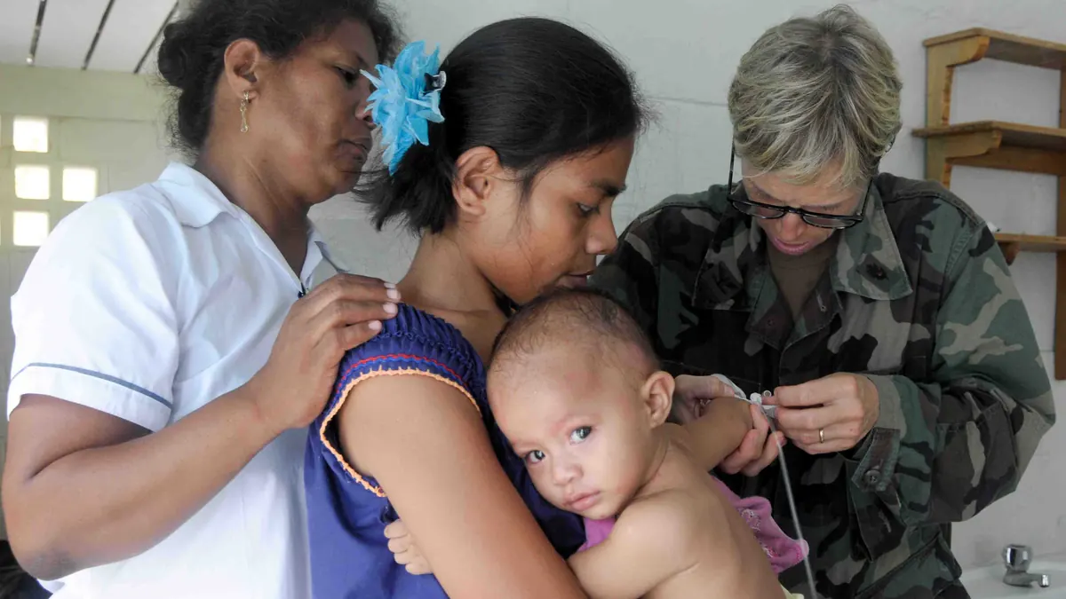 Healthcare physician using a medical stethoscope to listen to an infant chest and lungs during an examination.