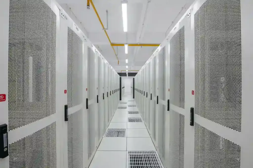 Rows of illuminated enterprise computer servers and network cables inside a modern cloud computing data center.