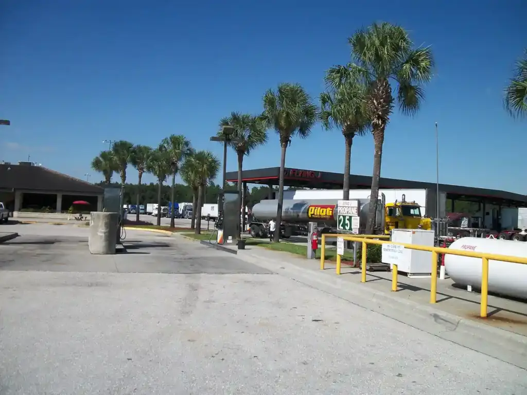 A heavy commercial truck tractor unit parked at a commercial diesel fueling station.