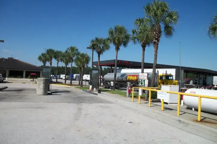 A heavy commercial truck tractor unit parked at a commercial diesel fueling station.