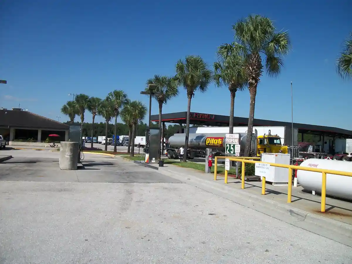 A heavy commercial truck tractor unit parked at a commercial diesel fueling station.