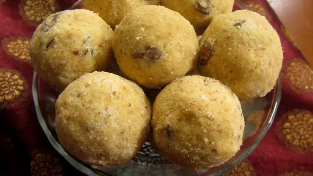 A plate of golden-brown besan ladoo sweets made from gram flour and sugar, arranged for Diwali sharing