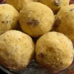 A plate of golden-brown besan ladoo sweets made from gram flour and sugar, arranged for Diwali sharing
