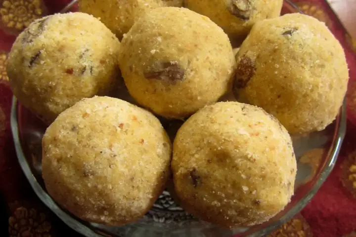 A plate of golden-brown besan ladoo sweets made from gram flour and sugar, arranged for Diwali sharing