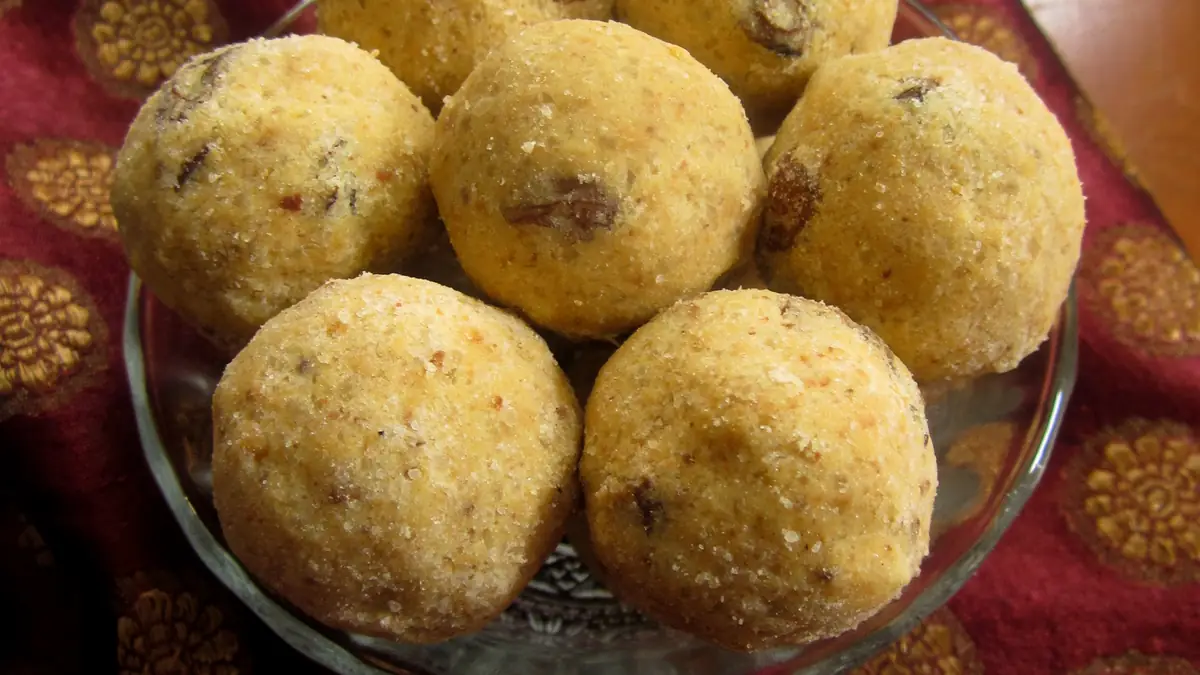 A plate of golden-brown besan ladoo sweets made from gram flour and sugar, arranged for Diwali sharing