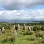 Prehistoric stone circle monument standing in a misty Irish field with weathered standing stones
