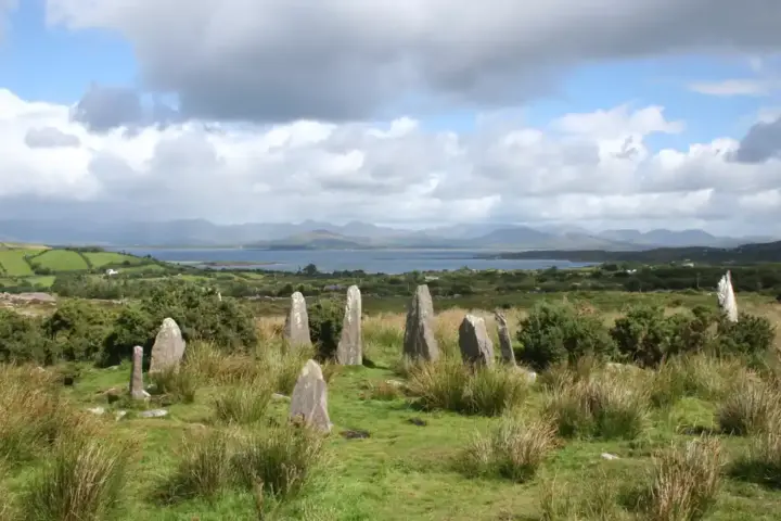 Prehistoric stone circle monument standing in a misty Irish field with weathered standing stones