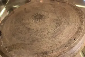 Detailed view of an ancient Vietnamese bronze drum displaying geometric patterns and central sunburst motifs.