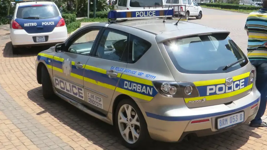 A white and blue South African Police Service patrol car parked on a city street in Durban, South Africa.