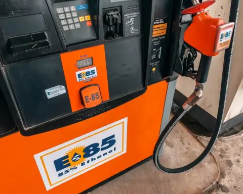 Detailed view of an E85 85 percent ethanol fuel pump nozzle and dispenser panel at an automotive service station.