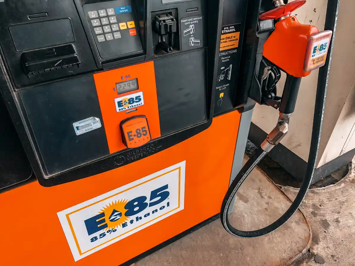 Detailed view of an E85 85 percent ethanol fuel pump nozzle and dispenser panel at an automotive service station.