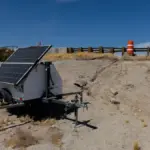 Automated license plate reader camera unit and power equipment stationed beside a roadway
