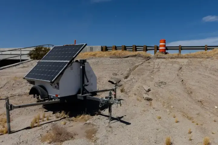 Automated license plate reader camera unit and power equipment stationed beside a roadway