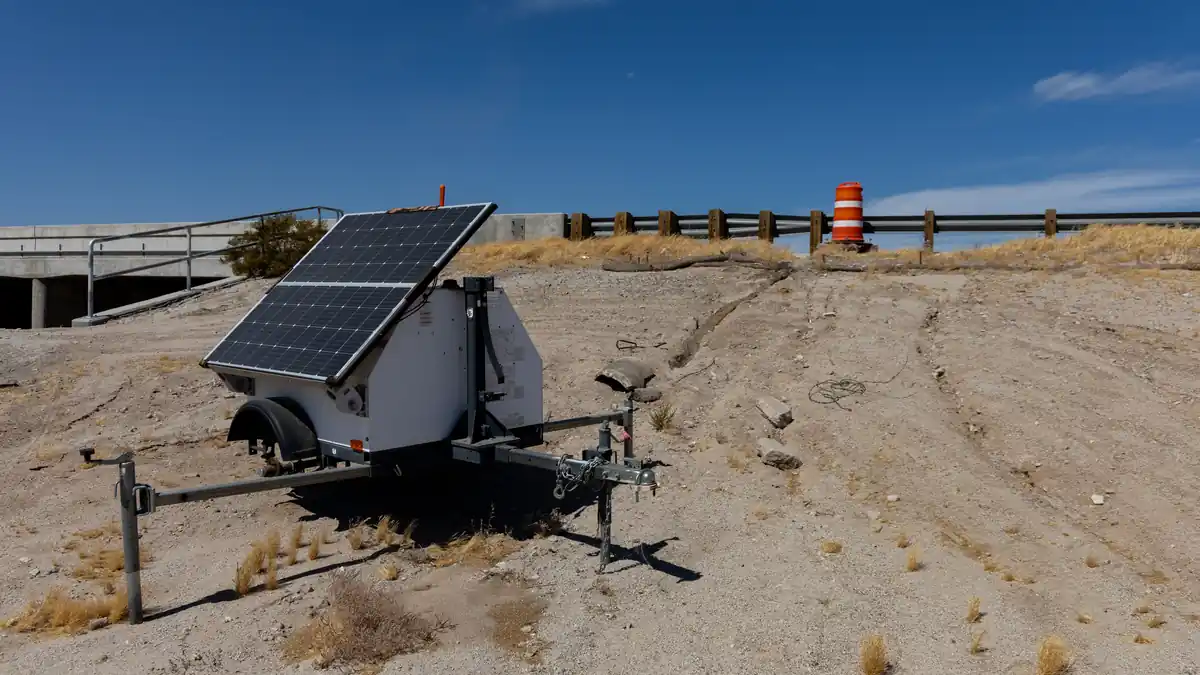 Automated license plate reader camera unit and power equipment stationed beside a roadway