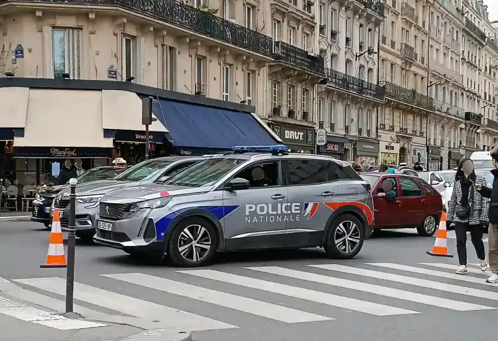 French National Police vehicles and crowd control units positioned along an urban street during a public protest.
