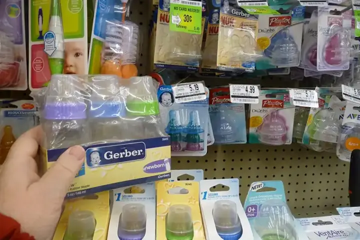 Several baby bottles on a shelf.