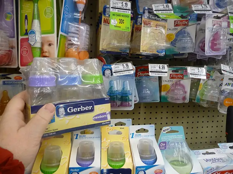 Several baby bottles on a shelf.