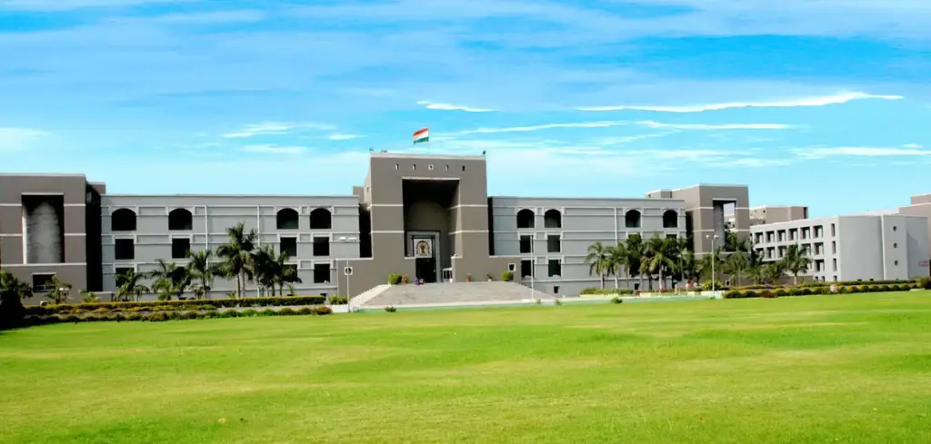Front architectural view of the Gujarat High Court judicial complex in Ahmedabad under an open sky.