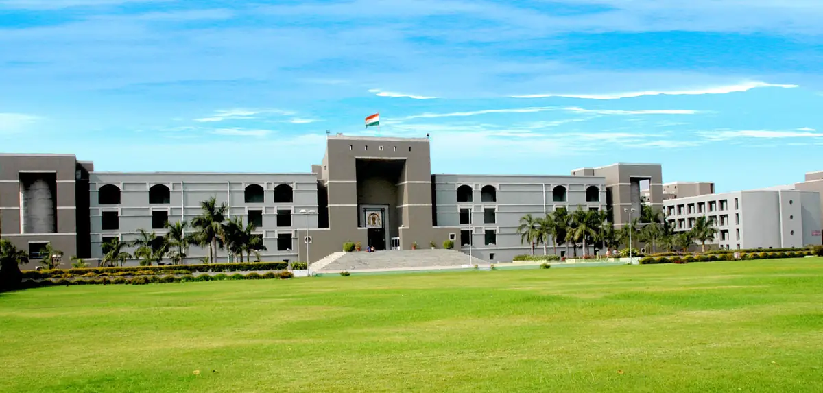Front architectural view of the Gujarat High Court judicial complex in Ahmedabad under an open sky.
