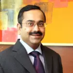 Anup Bagchi wearing spectacles and a business suit during an executive corporate portrait session representing HDFC Bank leadership transition