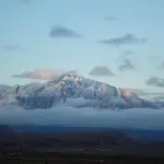 Panoramic view of the arid, snow-dusted peaks of the Hindu Kush mountain range rising into the sky.