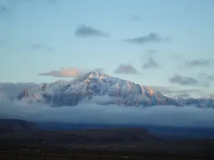Panoramic view of the arid, snow-dusted peaks of the Hindu Kush mountain range rising into the sky.