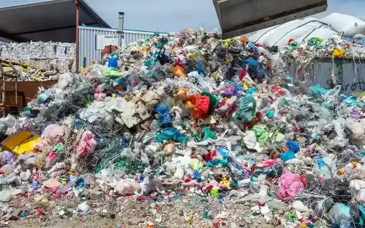 Baled and loose plastic waste at a recycling facility.