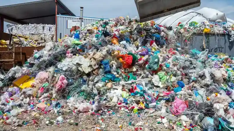 Baled and loose plastic waste at a recycling facility.