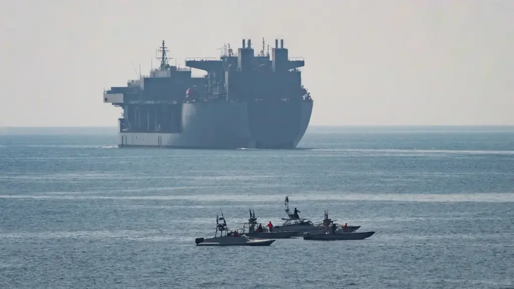 US Navy expeditionary mobile base ship and small patrol boats in the Strait of Hormuz