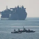US Navy expeditionary mobile base ship and small patrol boats in the Strait of Hormuz