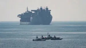 US Navy expeditionary mobile base ship and small patrol boats in the Strait of Hormuz