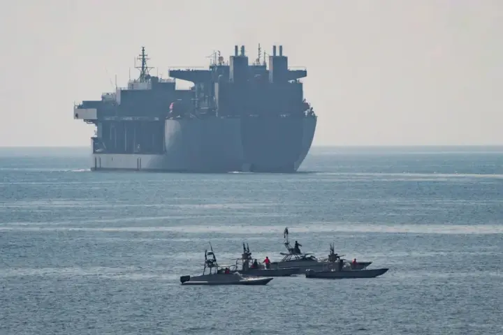US Navy expeditionary mobile base ship and small patrol boats in the Strait of Hormuz