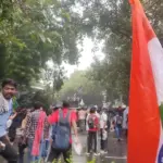Wide photograph of young citizens and students gathering with protest placards along the designated demonstration street at Jantar Mantar, New Delhi.
