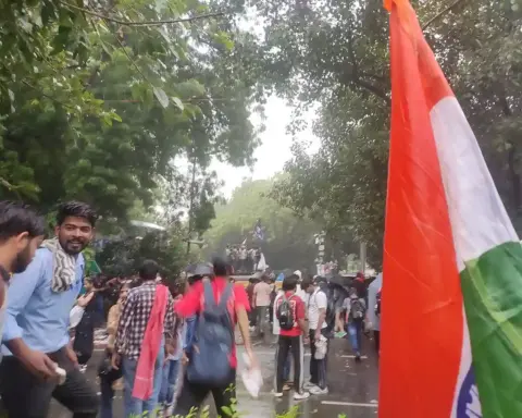 Wide photograph of young citizens and students gathering with protest placards along the designated demonstration street at Jantar Mantar, New Delhi.