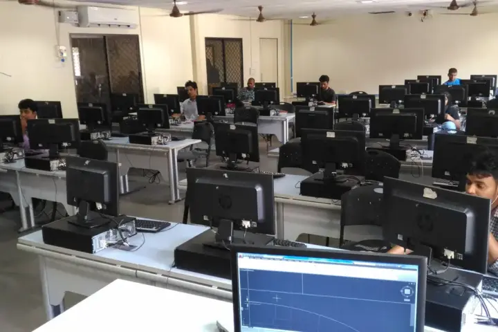 Students sitting at computer workstations in a university computer lab for JEE Main registration