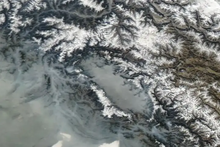 Satellite image showing the Kashmir Valley with mountain ranges and agricultural plains under clear weather conditions